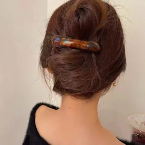 Close-up of a tortoiseshell acetate hair clip on a elegant low bun hairstyle.