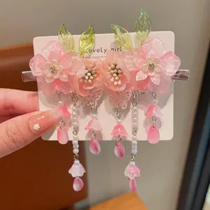 Primer plano detallado de pinzas para el cabello con flores rosas y cuentas en tarjeta.