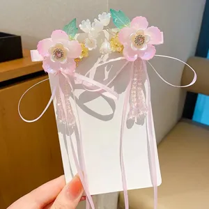 Detalle de horquillas de flores Hanfu rosas con largos lazos de cinta y cuentas