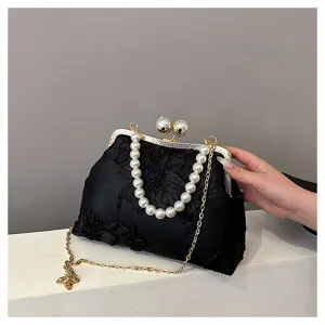 Detail view of black floral lace clutch featuring elegant pearl handle and gold chain