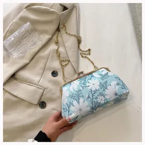 Detailansicht der blauen Stickerei und des Goldverschlusses an einer Vintage-Clutch