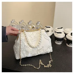 Detail of white floral lace embroidery bag with pearl handle and golden chain