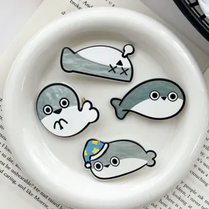 Close-up of four cute Sacabambaspis meme hair clips on a decorative white plate