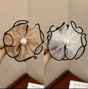 Detail shot of flower-shaped mesh hair claws with pearls in beige and white colors.