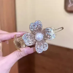 Elegant close-up view of a shimmering rhinestone and pearl four-leaf clover hair claw clip