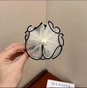 Detail view of elegant white mesh flower hair claw clip with central pearl embellishment