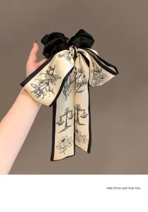 Dettaglio dell'elastico in raso vintage con fiocco e stampe floreali e bilancia