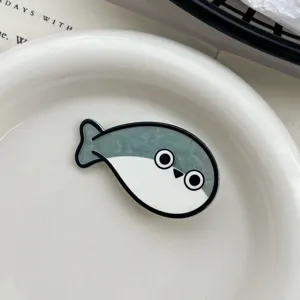 Detailed shot of a cute Sacabambaspis fish hair clip on a white ceramic plate.