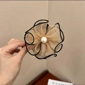Detailed view of a floral mesh hair claw clip with a central pearl and black trim.