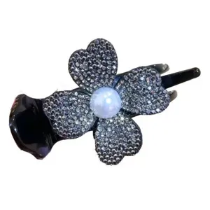 Sparkly rhinestone and pearl four-leaf clover hair claw clip for elegant hairstyles.