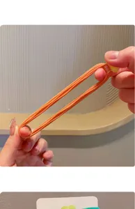 Primo piano dell'elevata elasticità e dello stiramento dell'elastico arancione per bambini.