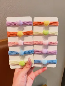 Primo piano di elastici per capelli colorati con ciondoli a stella e cuore per bambine
