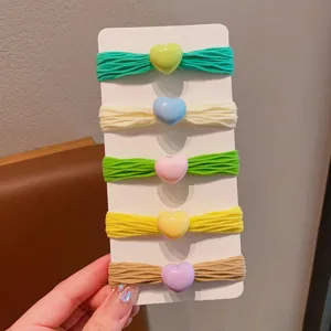 Vista dettagliata di elastici colorati a forma di cuore per bambine su cartoncino.