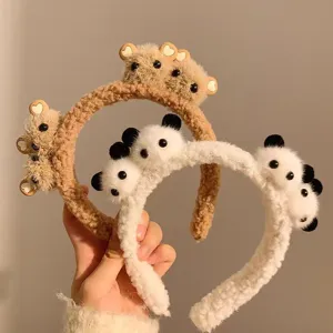 Close-up view of cute plush panda and bear headbands featuring soft fuzzy textures.