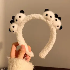 Close-up of cute plush panda heads on a soft fuzzy white headband hair accessory
