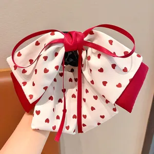 Détail d'une jolie pince à cheveux nœud avec motifs de cœurs rouges
