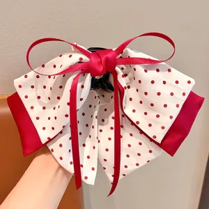 Gros plan d'une jolie pince à cheveux à nœud rouge à pois pour le style fille