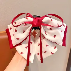 Vue détaillée de la pince à cheveux à nœud multicouche rouge et blanc pour petites filles