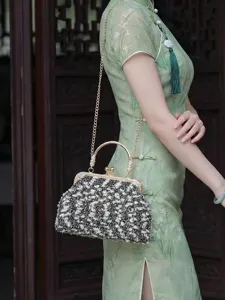 Vue détaillée d'un sac coquille en tweed avec fermoir à baiser