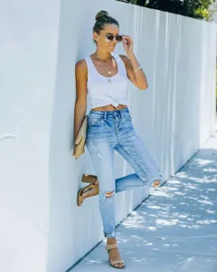 Casual slim ripped skinny jeans detail shot, high waist button fly denim trousers outdoors.