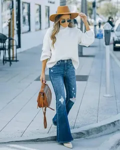 Close-up detail shot of women's stretch ripped flare jeans, stylish street style outfit.