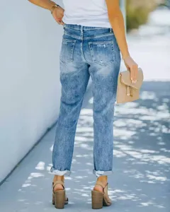 Jean femme bleu déchiré élégant pantalon long en denim avec revers pour le printemps.