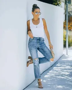Gros plan sur un jean bleu tendance pour femme avec des détails déchirés, idéal pour le printemps.
