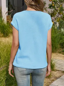 Back view detail of casual light blue short-sleeve knitted top worn with denim jeans outdoors.