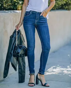 Women's dark blue skinny denim pants detail shot, slim fit streetwear fashion styling.