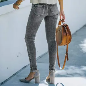 Detail view of gray acid wash skinny jeans showing back pockets and fitted leg silhouette.