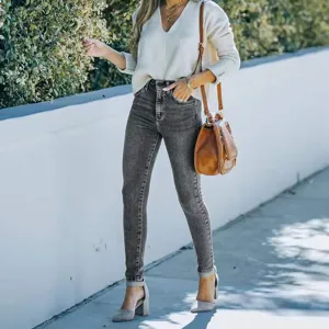 Outdoor street style detail shot featuring grey skinny stretch denim jeans paired with heels.