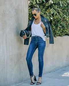 Slim fit washed denim jeans detail view, paired with casual top and jacket outdoor.