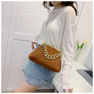 Modell trägt eine schicke braune Falten-Muscheltasche mit dicker goldener Kette.