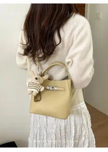 Minimalistische Beuteltasche aus Leder mit Metallschloss und Hundeanhänger