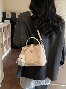 Sac seau beige élégant à grain de litchi avec un charmant petit chien blanc en peluche