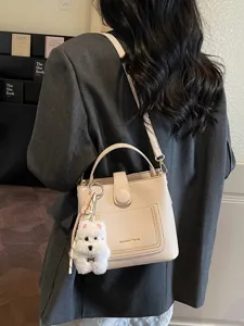 Sac seau élégant beige à motif litchi pour femme avec charmant pendentif chien blanc