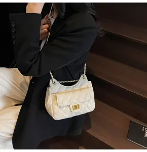 Close-up of elegant white quilted shoulder bag featuring gold-tone lock and chain strap