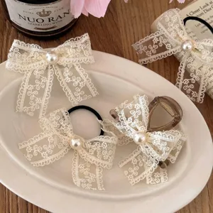 Ensemble de pinces à cheveux vintage en dentelle crème avec nœuds sur assiette.