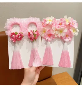 Close-up of traditional Chinese floral hair ties with ombre pink tassels and ruffles
