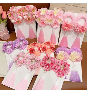 Variety of traditional floral hair scrunchies with tassels in pink and purple tones.
