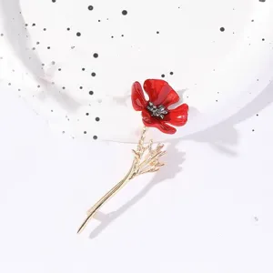 Detaillierte Ansicht einer Vintage-Brosche mit roter Emaille-Blume und goldenem Stiel