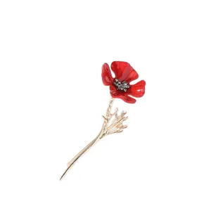 Detaillierte Makroansicht einer roten Emaille-Mohnblumen-Brosche mit goldenem Stiel