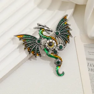 Primo piano di una spilla a forma di drago volante vintage con smalto verde e oro.