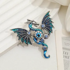 Primo piano di spilla drago vintage in smalto con cristalli blu e occhio steampunk