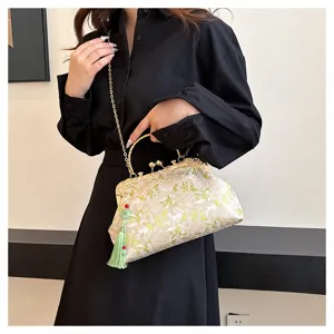 Detailed view of floral embroidery on a vintage-style handbag with green tassel