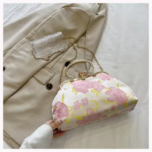 Vintage floral jacquard shell bag featuring a gold handle and chain strap on blazer