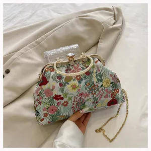 Detailed shot of floral jacquard shell bag with ornate metal handle and gold chain strap