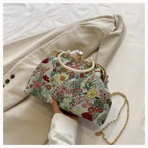 Elegant floral tapestry clutch bag with gold-tone kiss-lock and metal chain strap.
