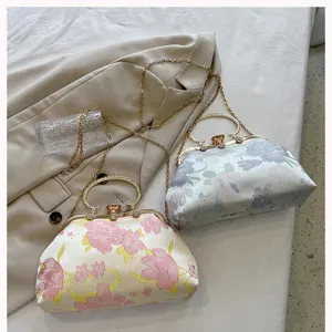 Detailed view of floral jacquard shell handbags with crystal clasp and chain