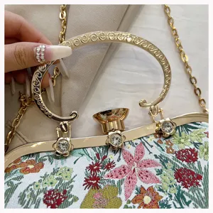 Close-up of vintage floral jacquard shell bag with ornate gold handle and crystal clasp